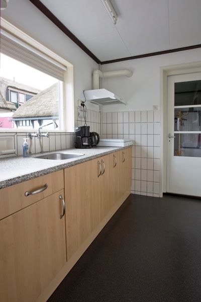 Moderne keuken van Hoe bestaat het vakantiehuis in Oosterend, Texel met functionele apparatuur.