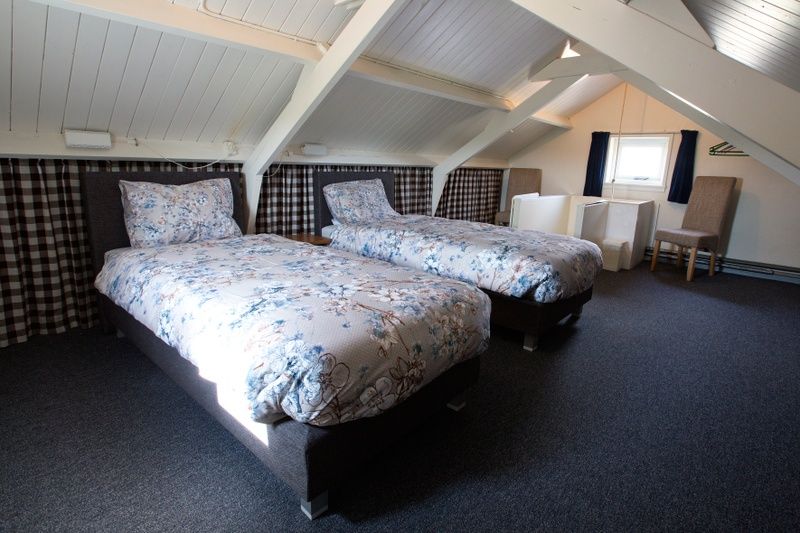 Ruime zolderkamer in Hoe bestaat het vakantiehuis in Oosterend, Texel met twee bedden.