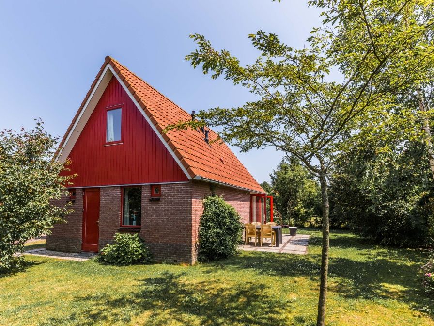 Typ II - Nr. 81 White Wagtail, rotes Ferienhaus in Oosterend, Texel, umgeben von Gruen.