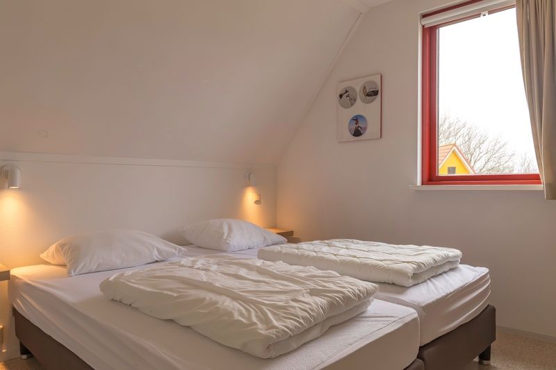 Gemuetliches Schlafzimmer im Ferienhaus Typ II - Nr. 81 Weisse Bachstelze, Oosterend, Texel, mit Blick auf die Umgebung.