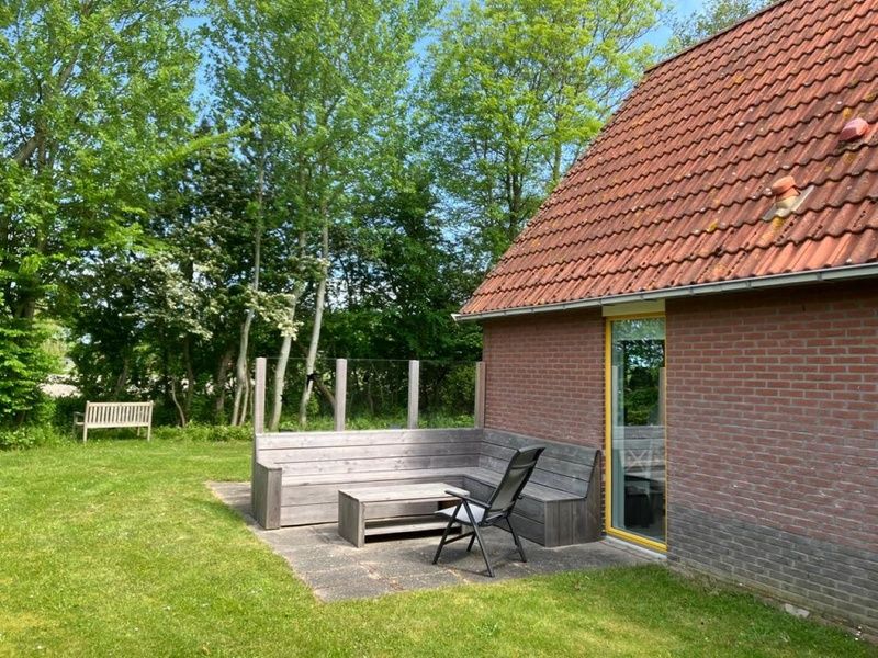 Cozy terrace at Type I - No. 89 Lark, vacation home in Oosterend, Texel, overlooking lush gardens.