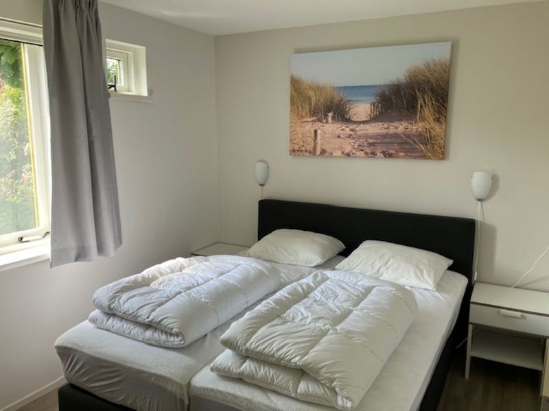Bedroom with double bed in Type I - No. 89 Lark, vacation home in Oosterend, Texel, with serene beach decoration.