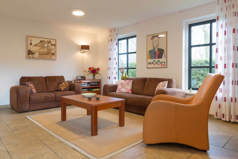 Gemuetliches Wohnzimmer in Typ III - Nr. 21B Fasan, Ferienhaus Oosterend Texel, mit bequemen Sofas und warmen Moebeln.