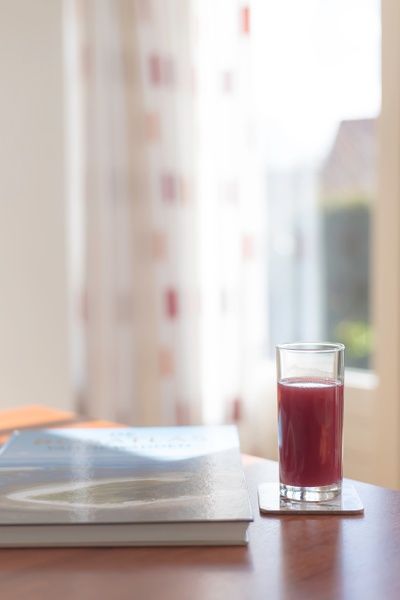 Entspannen Sie sich in Typ III - Nr. 21B Fasan, Ferienhaus Oosterend Texel, bei einem Glas Saft und Gartenblick.