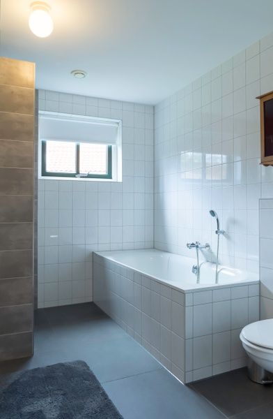 Modernes Badezimmer in Typ III - Nr. 21B Fasan, Ferienhaus Texel, mit Badewanne und glatten Fliesen.