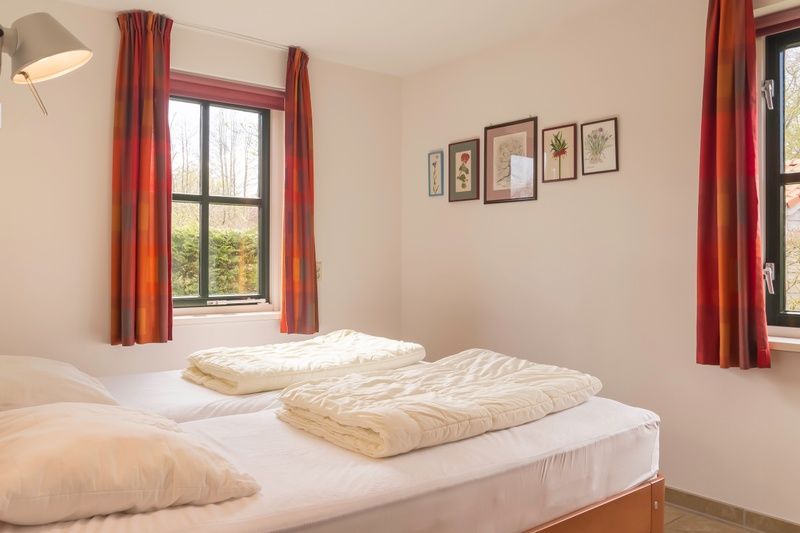 Schlafzimmer in Typ III - Nr. 21B Fasan, Ferienhaus Oosterend Texel, mit Doppelbett und bunten Vorhaengen.