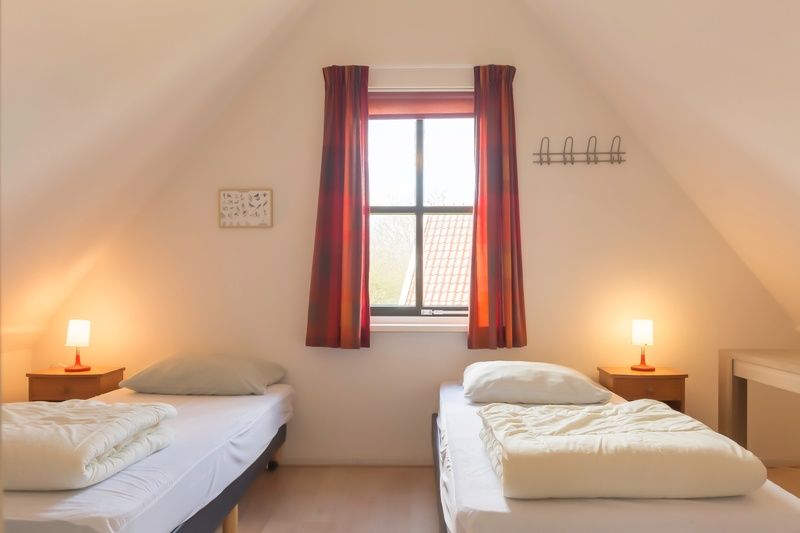 Gemuetliches Mansardenzimmer in Typ III - Nr. 21B Fasan, Ferienhaus Texel, mit zwei Einzelbetten und Dachfenster.