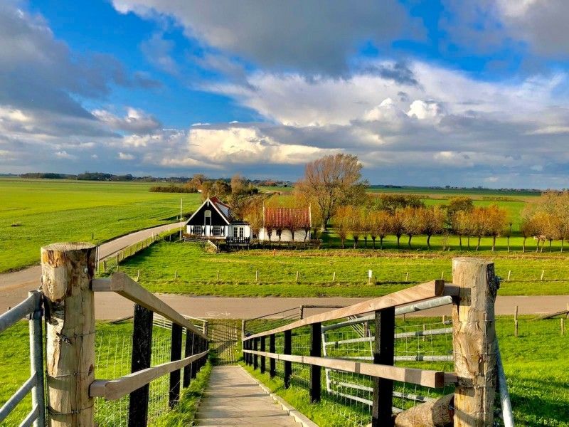 't Kaaps Huussie vakantiehuis in Oosterend, Texel met weids uitzicht over groene velden en landelijke omgeving.