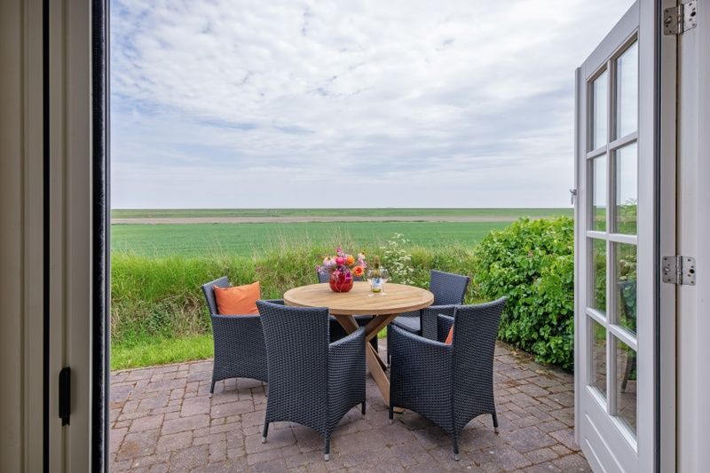 Blick von der Terrasse von De Waddenschelpjes - De Mossel in Oosterend, Texel ueber die gruenen Felder.