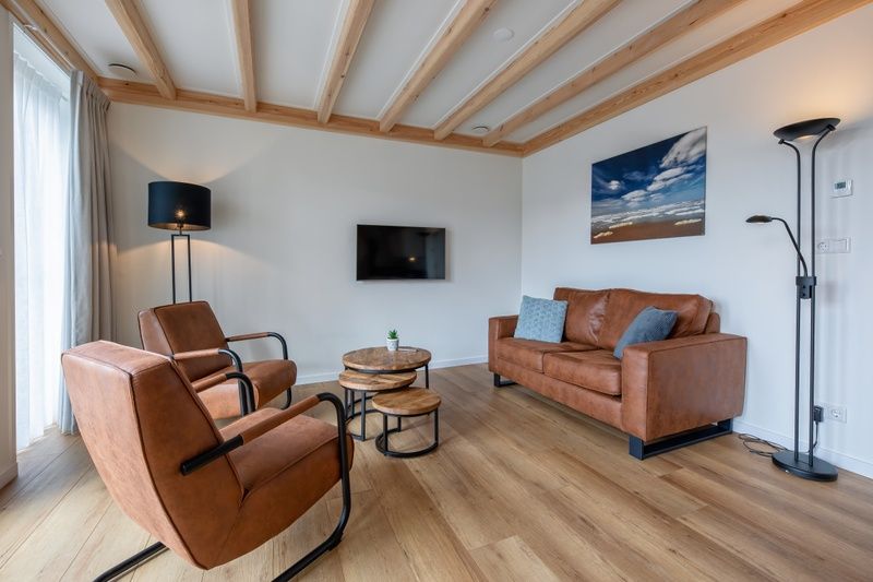 Stylish sitting area in Apartment C, Oudeschild, with comfortable leather chairs and sofa.