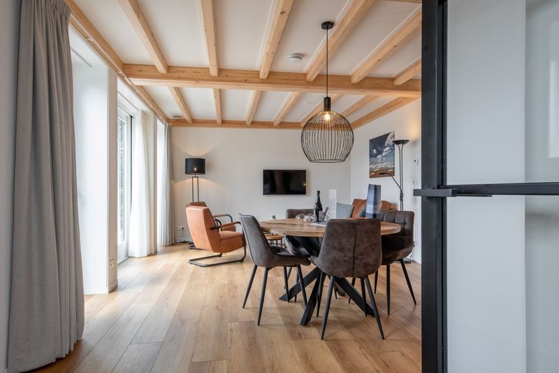 Spacious dining room in Apartment C, Texel, with wooden dining table and lots of natural light.