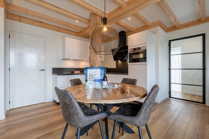 Modern kitchen of Apartment C, Texel, with dining table and stylish lamp.