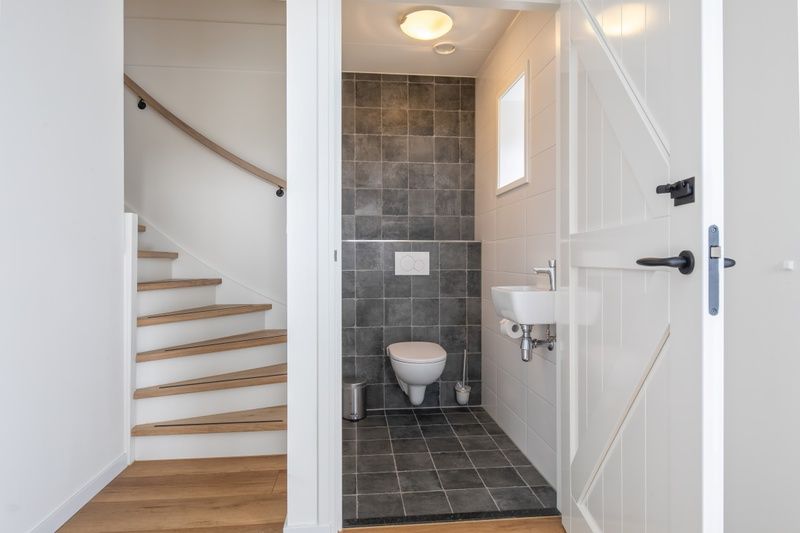 Practical hall of Apartment C, Oudeschild, with stairs and access to toilet.