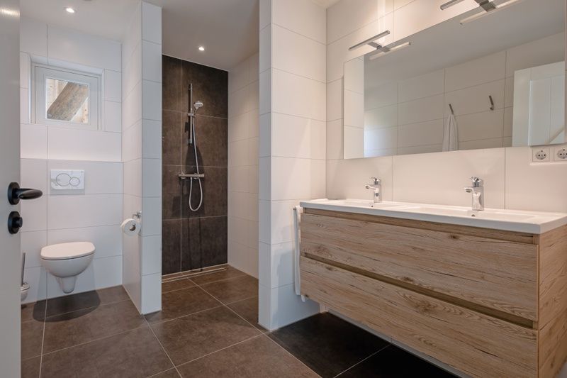Luxury bathroom of Apartment C, Texel, with double sink and walk-in shower.
