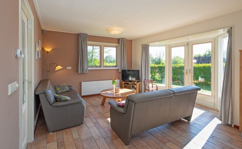 Gemuetliches Wohnzimmer im Ferienhaus 8690 - Junier - Huisman, Zuid-Eierland, Texel, mit viel Tageslicht und Blick auf den Garten.