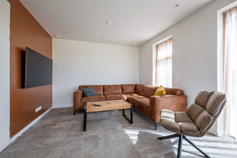 Gemuetliches Wohnzimmer im Ferienhaus De Zuidbunder auf Texel mit bequemem Sofa und moderner Einrichtung.