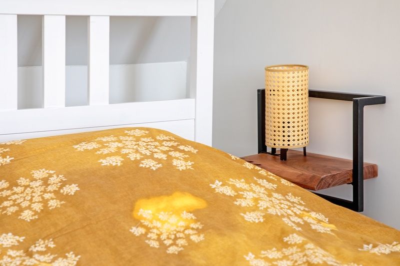 Gemuetlicher Nachttisch in De Zuidbunder, Texel, mit stimmungsvoller Lampe und Holzdetails.