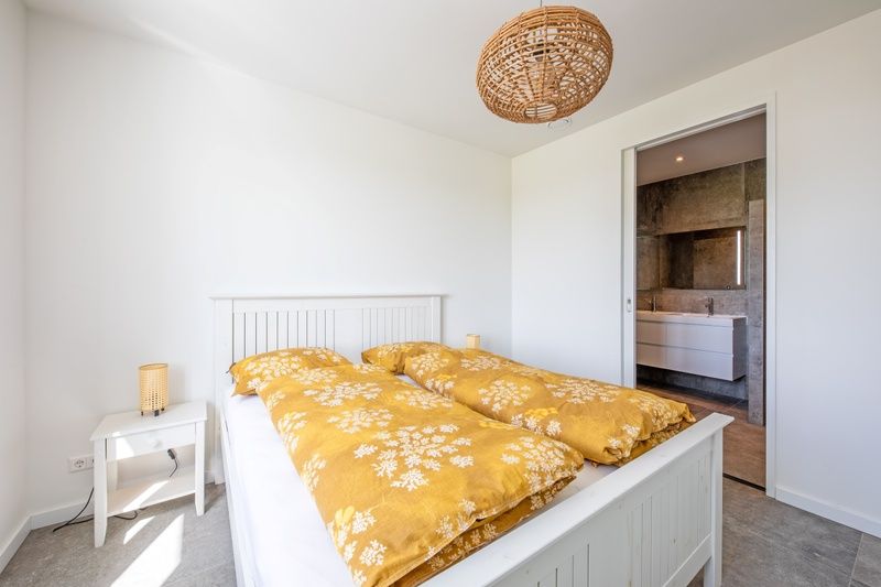 Helles Schlafzimmer im De Zuidbunder Ferienhaus Texel, mit eigenem Badezimmer.