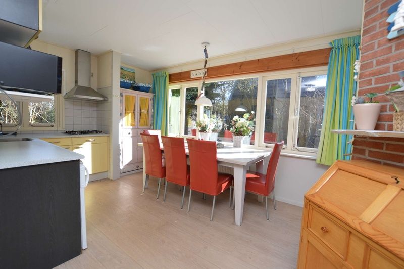 Eethoek in Vakantiehuis De Nagtegaal 15, De Wulk, De Dennen, Texel, met grote ramen en veel natuurlijk licht.