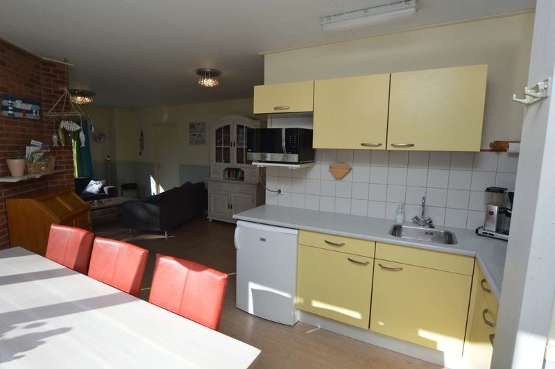 Open keuken en eetruimte in Vakantiehuis De Nagtegaal 15, De Wulk, Texel, perfect voor familiediners.