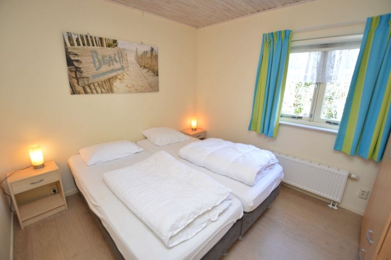 Gezellige tweepersoons slaapkamer in Vakantiehuis De Nagtegaal 15, De Wulk, Texel met stranddecor.