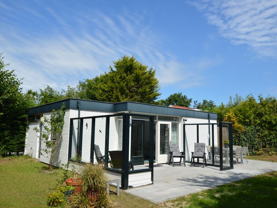 Vakantiehuis de Parel 182 in De Dennen, Texel met zonnig terras en groene omgeving.