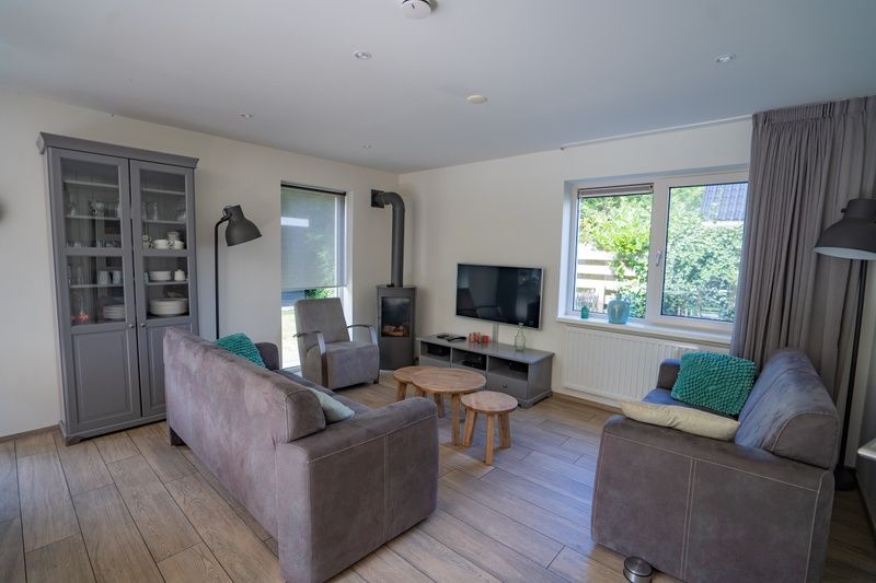 Innenraum Ferienhaus de Parel 150 in De Dennen, Texel mit Sitzecke und grossen Fenstern.