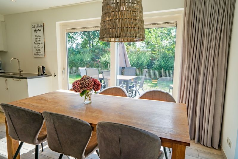 Essecke im Ferienhaus de Parel 150 in De Dennen, Texel mit Blick auf die gruene Umgebung.