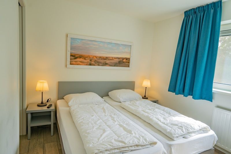 Schlafzimmer im Ferienhaus de Parel 150 in De Dennen, Texel mit Doppelbett und ruhiger Atmosphaere.
