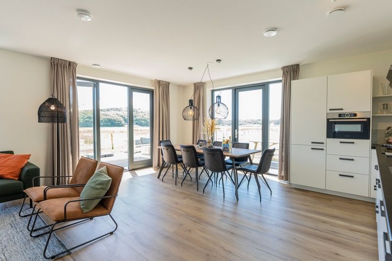 Helles Esszimmer und Kueche im Ferienhaus 2, De Dennen, Texel mit Blick auf die Watteninseln.