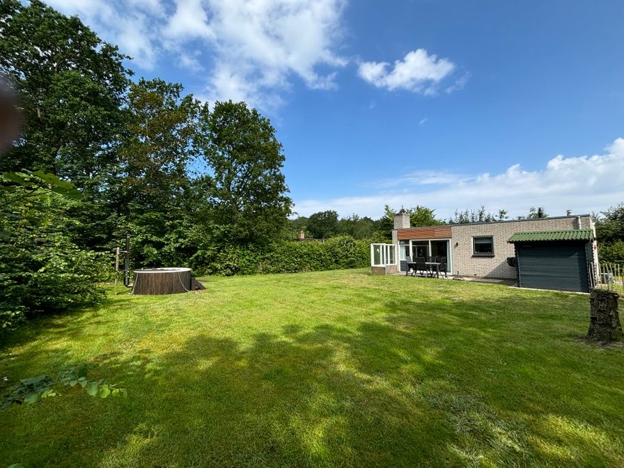 Ruime tuin van vakantiehuis de Parel 162 in Bungalowpark de Parel, De Dennen, Texel, omgeven door groen.