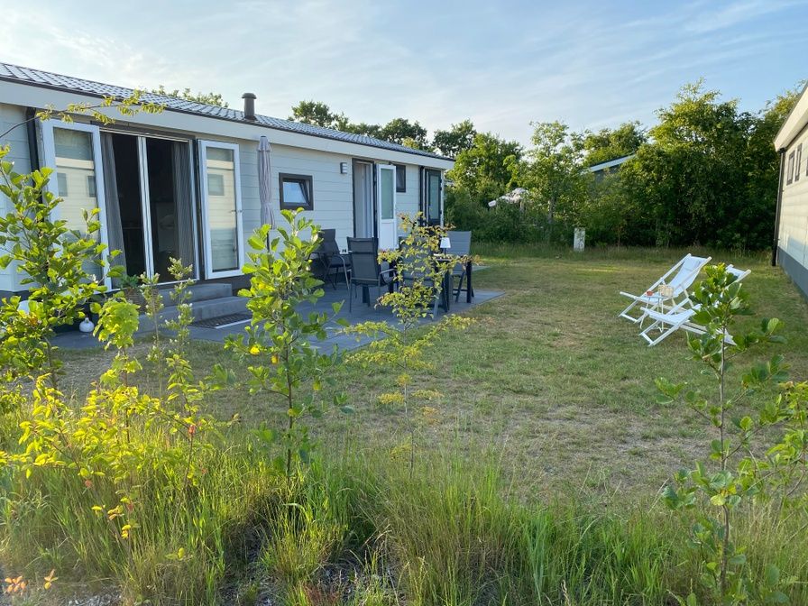 Vakantiepark de Bremakker - Bosveld 148 in De Dennen, Texel biedt een charmant terras met comfortabele zitplaatsen en groene omgeving.