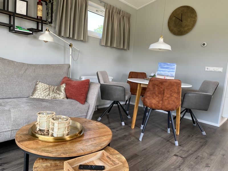 Eetgedeelte van Vakantiepark de Bremakker - Bosveld 148 in De Dennen, Texel met stijlvolle stoelen en warme sfeer.