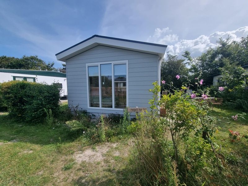 Vooraanzicht van vakantiehuis op Vakantiepark de Bremakker, Bosveld 135, De Dennen, Texel met bloeiende tuin.