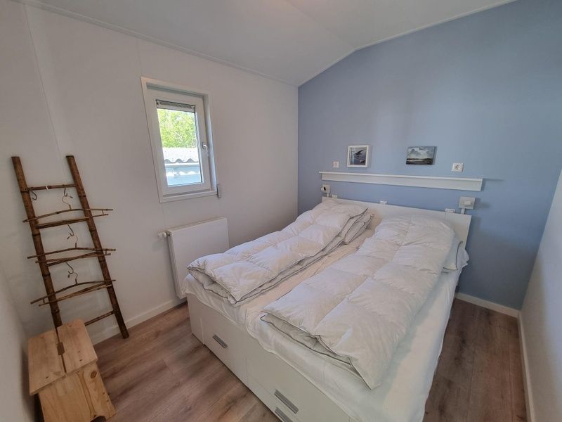 Slaapkamer met tweepersoonsbed in Vakantiepark de Bremakker, Bosveld 135, De Dennen, Texel, voor een rustgevende nacht.