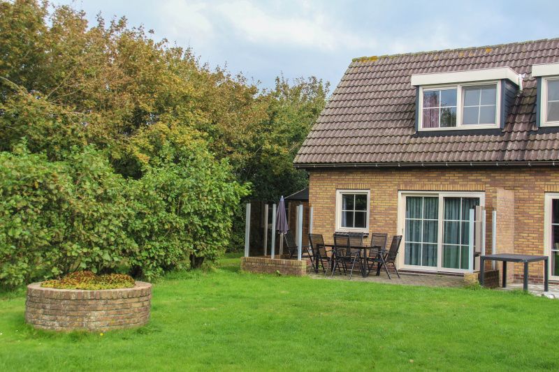 Gemuetliche Terrasse im Ferienhaus Duif in De Dennen, Texel, umgeben von Natur.