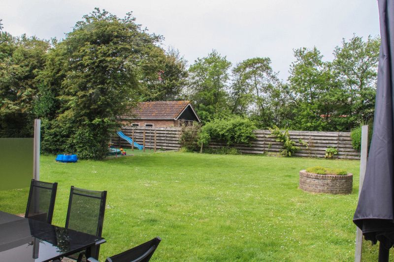 Geraeumiger Garten des Ferienhauses Dove, De Dennen, Texel mit Spielplatz fuer Kinder.