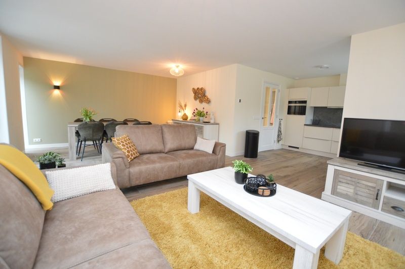 Offenes Wohnzimmer und Kueche im Ferienhaus De Nagtegaal 23, De Dennen Texel, mit moderner Ausstattung.