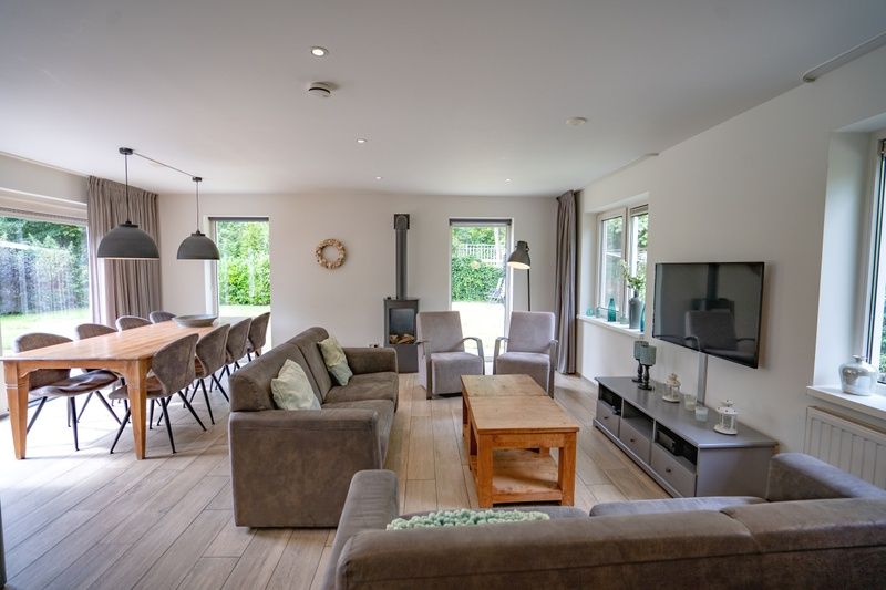 Gemuetliches Wohnzimmer des Ferienhauses de Parel 152 in De Dennen, Texel mit Blick auf den Garten.