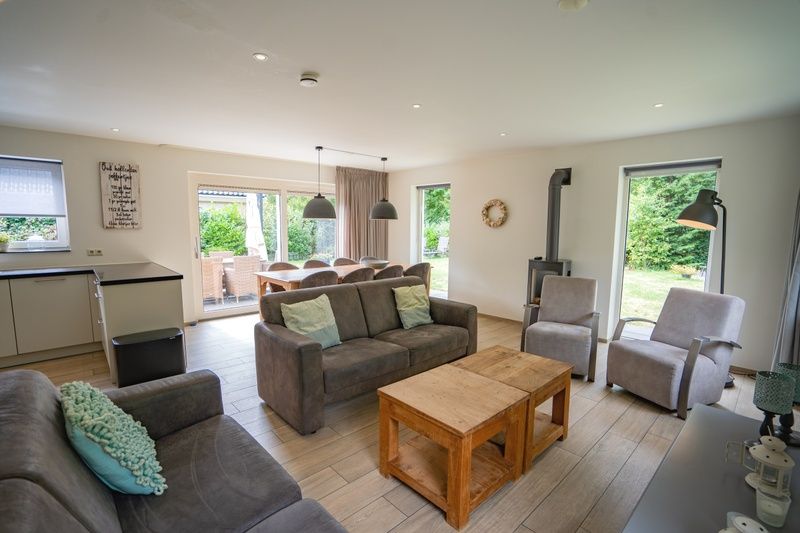 Offener Wohnbereich im Ferienhaus de Parel 152, Texel mit moderner Einrichtung und Gartenblick.