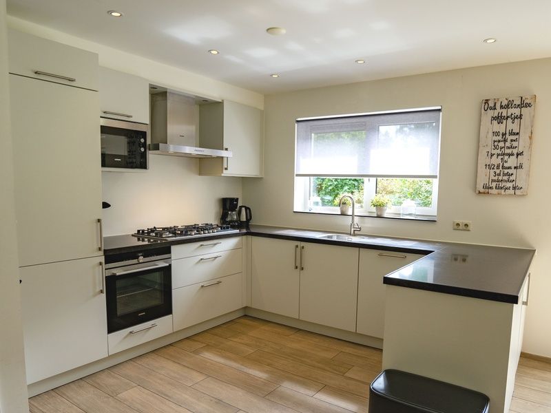 Moderne Kueche im Ferienhaus de Parel 152, De Dennen, Texel mit Blick auf die Natur.