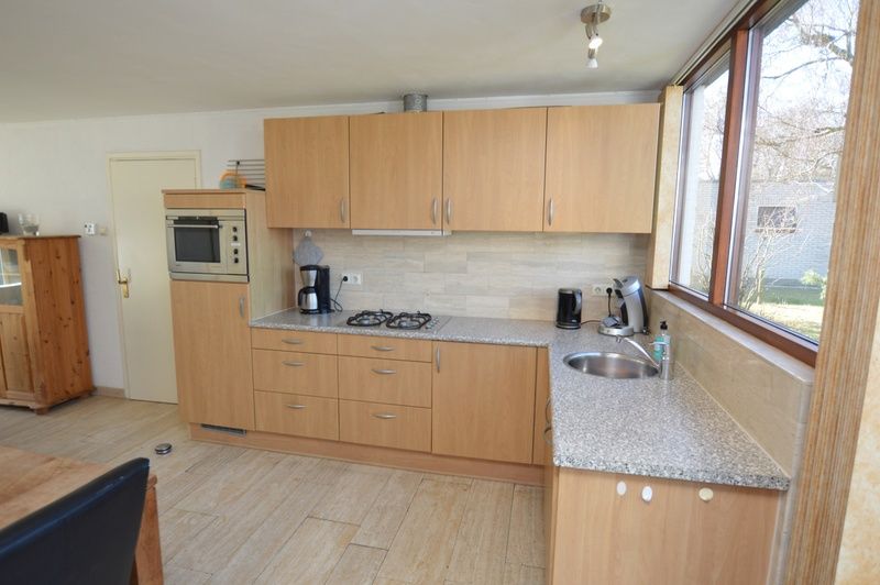 Voll ausgestattete Kueche des Ferienhauses de Parel 198 in De Dennen, Texel mit grosszuegigen Arbeitsflaechen und Blick auf die Natur.