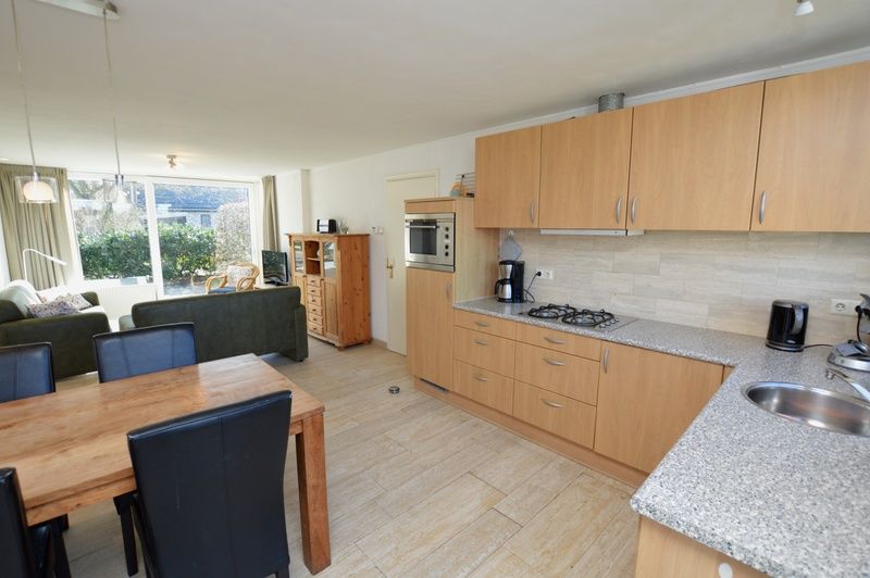 Offene Kueche und Esszimmer im Ferienhaus de Parel 198 in De Dennen, Texel, mit viel Licht und moderner Ausstattung.