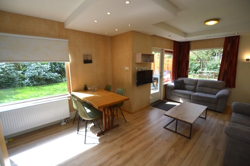 Lichte woonruimte van Vakantiehuis De Nagtegaal 19 in De Dennen Texel met uitzicht op groene tuin.