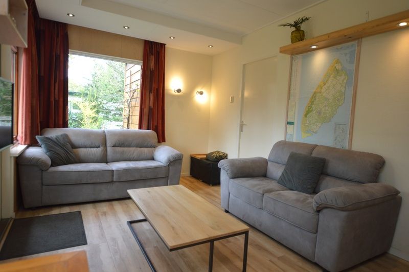 Gezellige woonkamer in Vakantiehuis De Nagtegaal 19, De Dennen Texel met comfortabele banken.