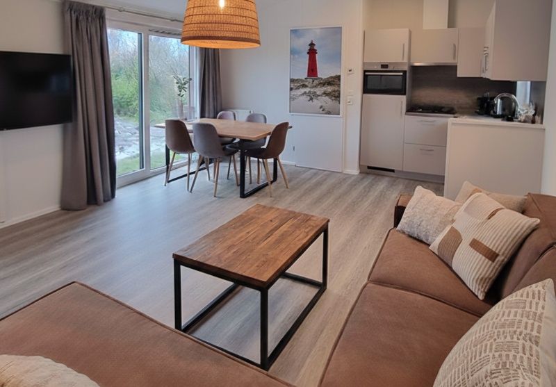 Gezellige woonkamer in Vakantiepark De Bremakker - Bosveld 137, De Dennen, Texel. Modern vakantiehuis met ruime zithoek en keuken.