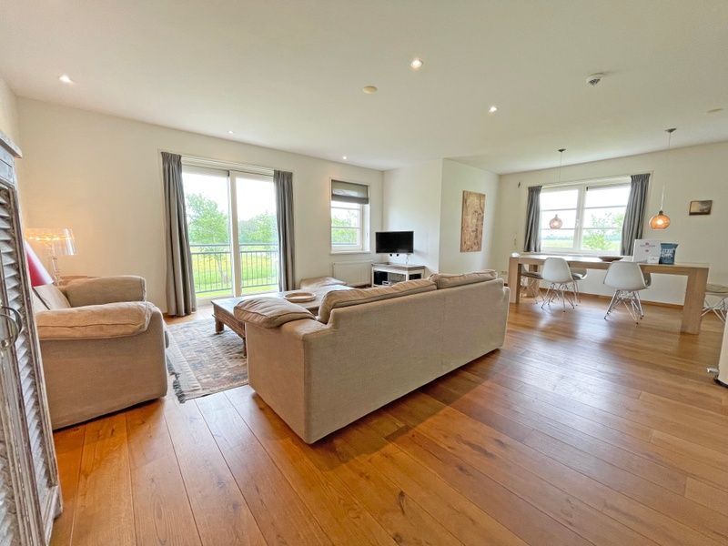 Offener Wohn- und Essbereich im Apartment Bos en Duin 40, De Dennen, Texel mit Blick auf die gruene Landschaft.