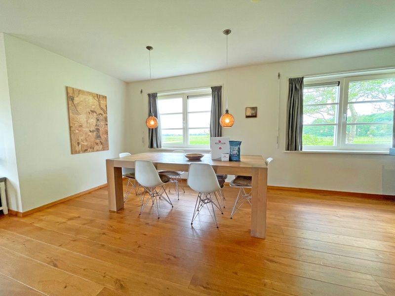 Essecke im Appartement Bos en Duin 40, De Dennen, Texel mit grossem Esstisch und Blick ins Freie.