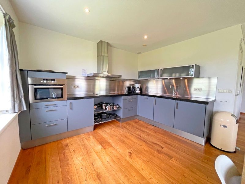 Moderne Kueche im Appartement Bos en Duin 40, De Dennen, Texel, mit Edelstahlausstattung und viel Stauraum.
