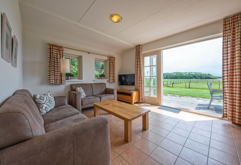 Gemuetliches Wohnzimmer von 't Mienthuis - De Jonker in De Dennen, Texel mit Blick auf gruene Felder.
